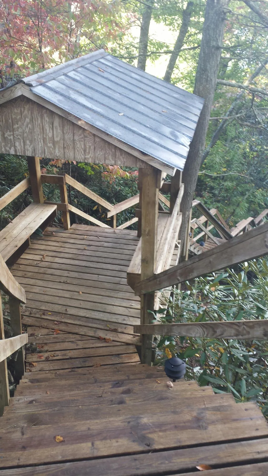 Metal roofed shelter over wooden steps on a wooded walkway — Skylight Repair & Installation work by our crew in Uniontown